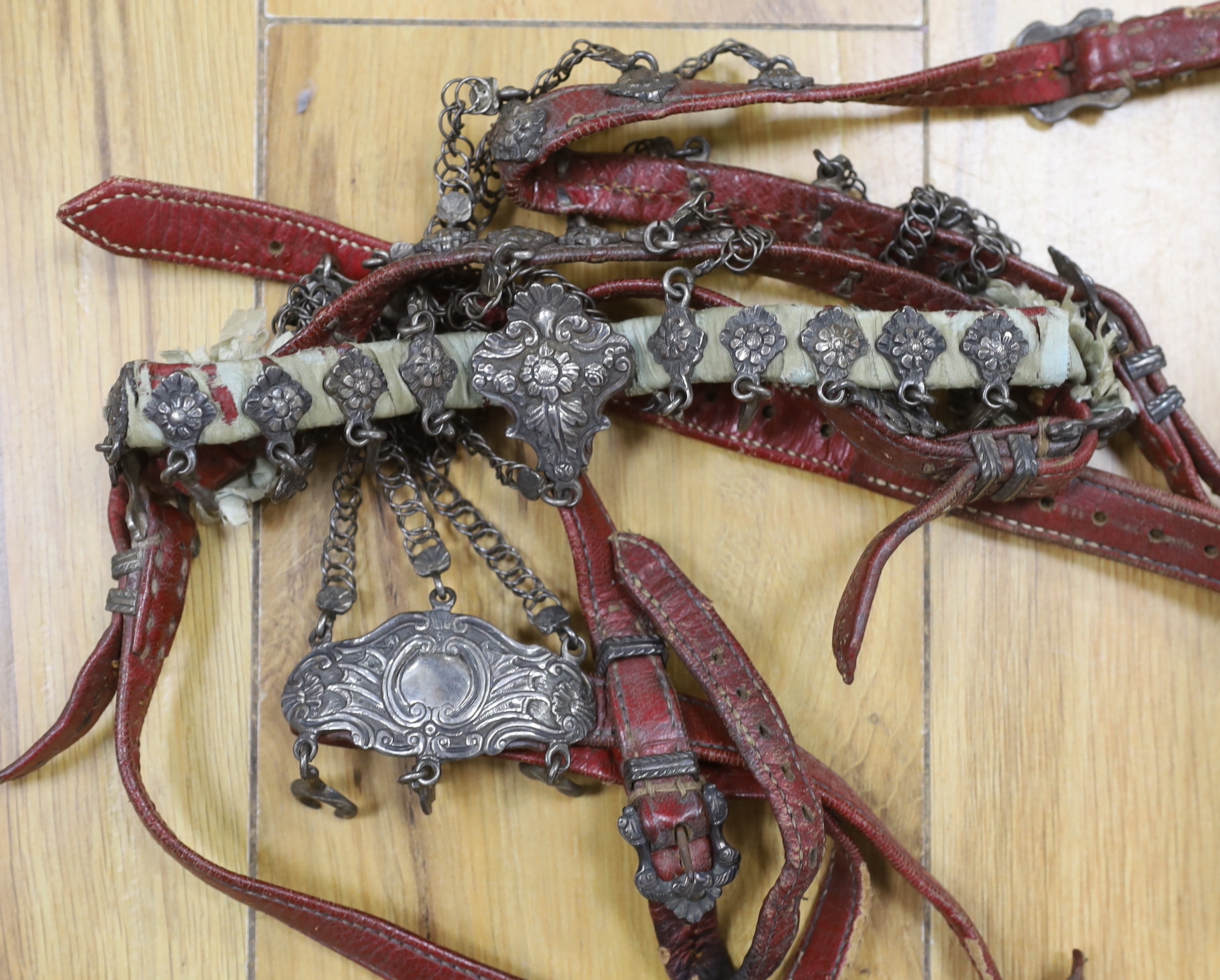 A 19th century white metal-mounted leather horse bridle and martingale